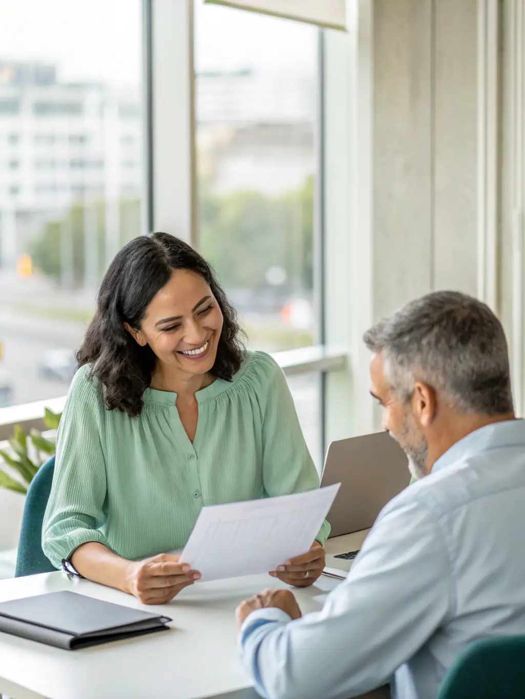 A business owner, a woman, thoughtfully reviewing transition plans with an Equity Shift Advisors consultant in a modern office setting, emphasizing personalized service.